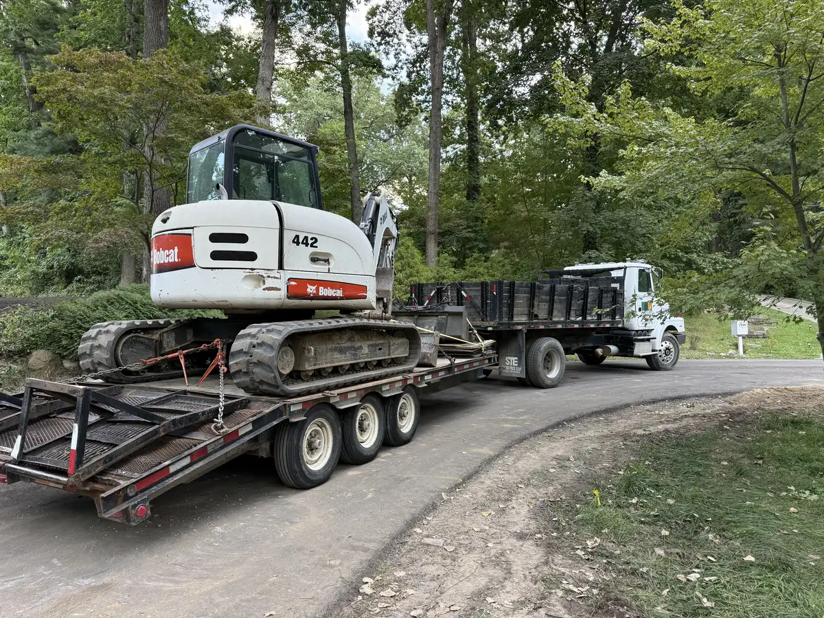 Bobcat excavator on trailer — Earth Art Landscaping fleet