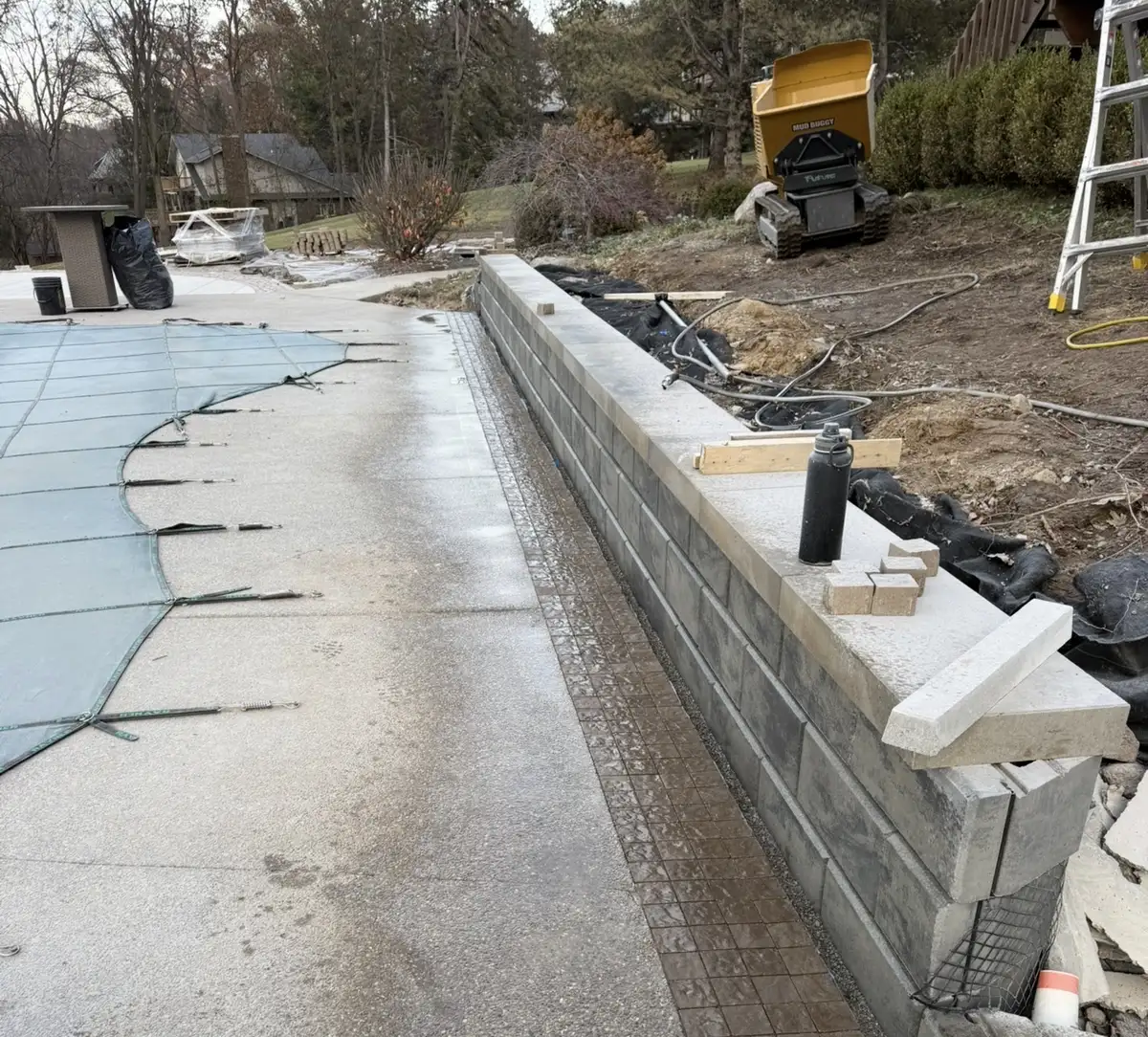 Techo-Bloc retaining wall installation near pool by Earth Art